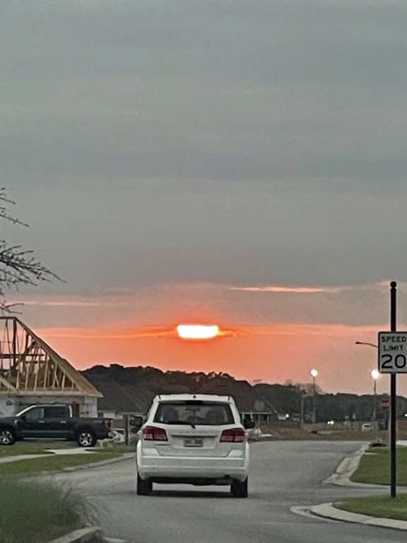 Photo of sun with clouds above and to the left right and a little below it.